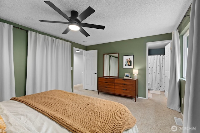 bedroom featuring visible vents, a textured ceiling, baseboards, light colored carpet, and ceiling fan