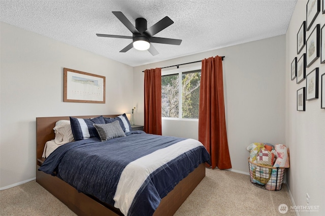 carpeted bedroom featuring baseboards, a textured ceiling, and ceiling fan