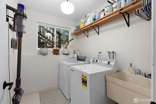 laundry room featuring a sink, washer and dryer, tile patterned flooring, baseboards, and laundry area