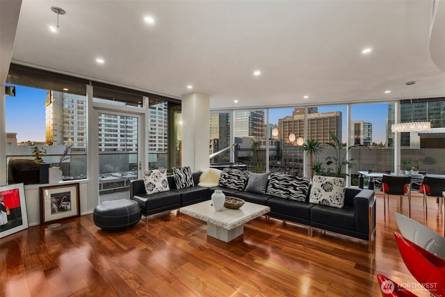 living room with a view of city, floor to ceiling windows, recessed lighting, and wood finished floors