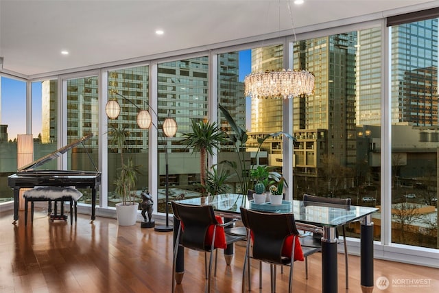 sunroom featuring a view of city and a chandelier