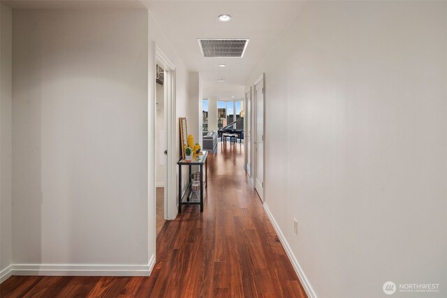 hallway with baseboards, visible vents, dark wood-style flooring, and recessed lighting