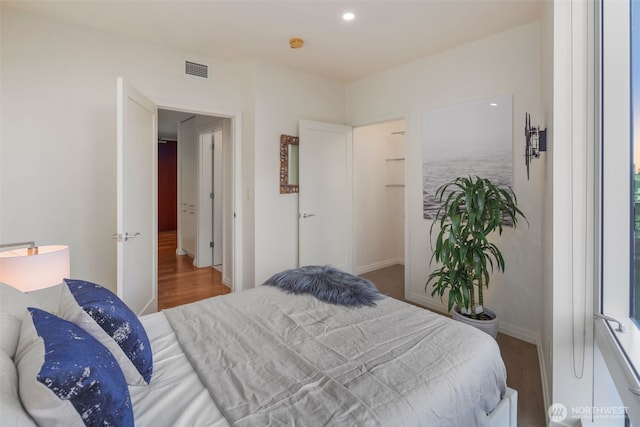 bedroom featuring recessed lighting, wood finished floors, visible vents, and baseboards