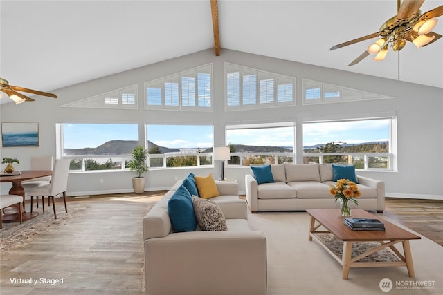 sunroom / solarium with lofted ceiling with beams, a mountain view, and a ceiling fan