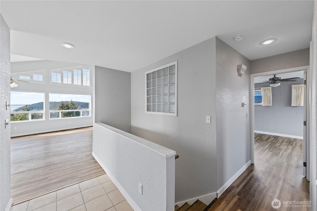 corridor with baseboards and wood finished floors