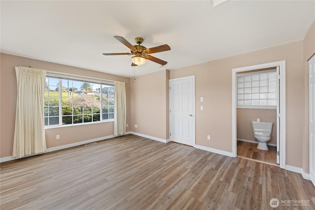 unfurnished bedroom with light wood-style floors, ceiling fan, ensuite bath, and baseboards