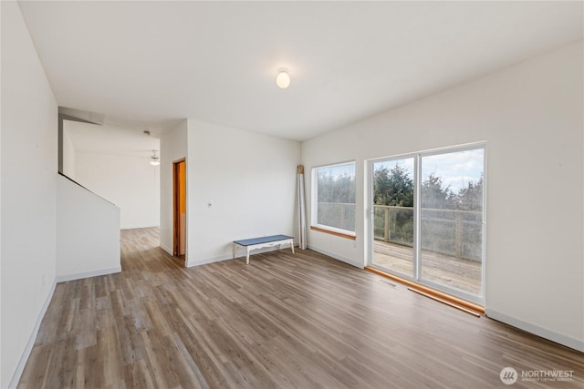 empty room with visible vents, baseboards, and wood finished floors