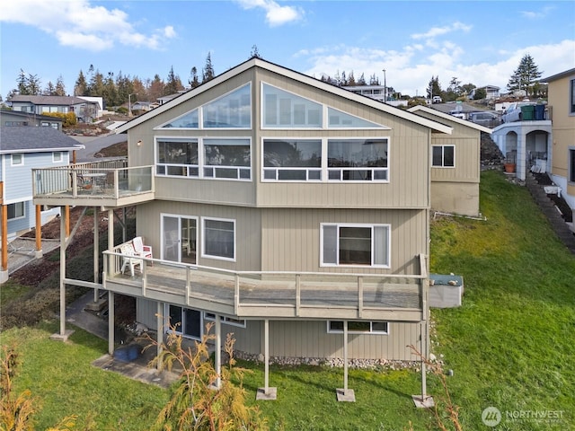 rear view of property featuring a patio area, a wooden deck, and a yard