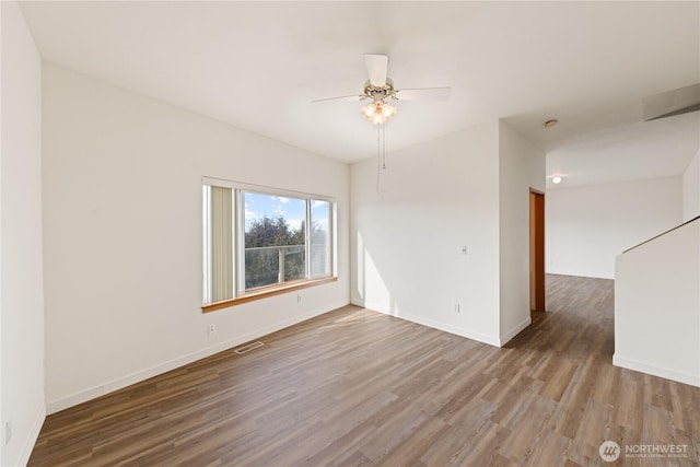 unfurnished room with visible vents, ceiling fan, baseboards, and wood finished floors