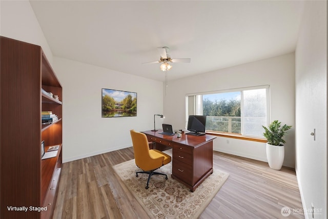 home office with light wood-style floors, baseboards, and a ceiling fan