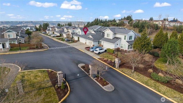 view of road featuring curbs, a gated entry, a gate, and a residential view