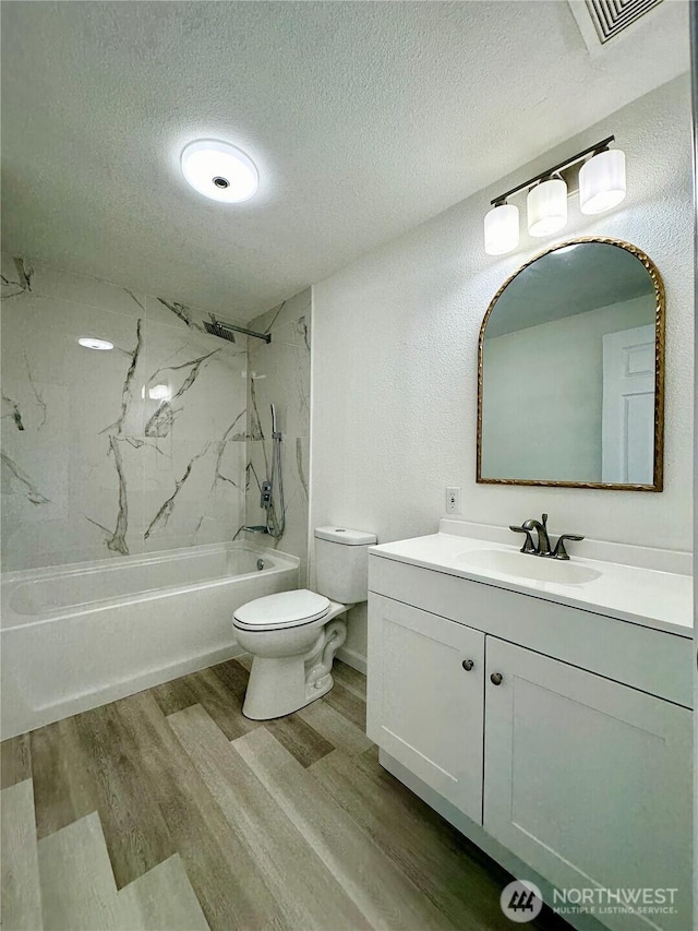 bathroom featuring visible vents, toilet, washtub / shower combination, a textured ceiling, and wood finished floors