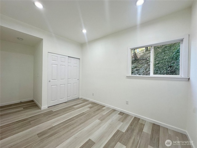 unfurnished bedroom featuring light wood-type flooring, baseboards, and recessed lighting