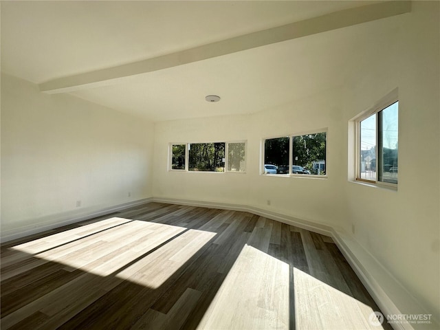 unfurnished room with dark wood-type flooring, beam ceiling, and baseboards