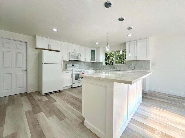 kitchen with white appliances, white cabinets, and backsplash