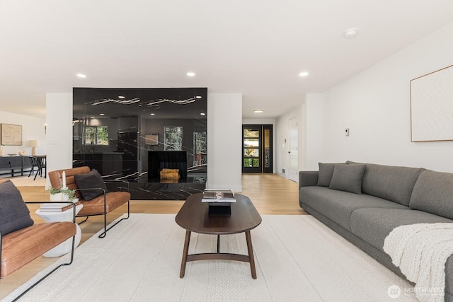 living room with plenty of natural light, light wood-type flooring, and recessed lighting