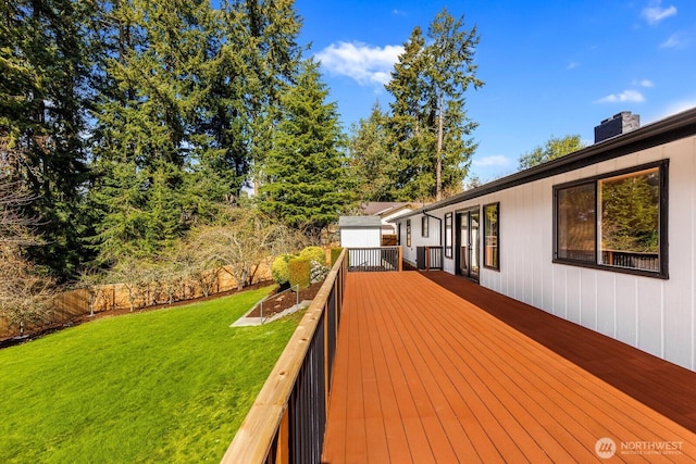 wooden terrace featuring fence and a yard