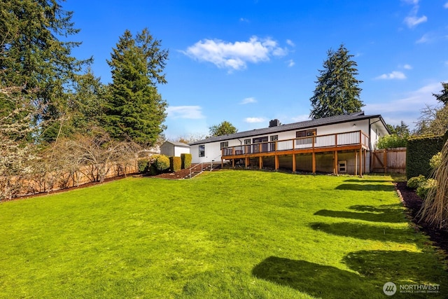 rear view of house with stairs, a lawn, a wooden deck, and fence