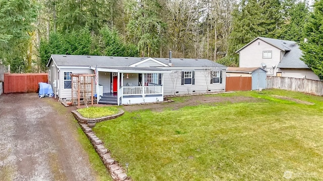 view of front facade featuring a front lawn, fence, covered porch, crawl space, and driveway