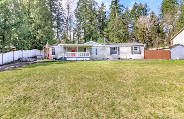 view of front of house featuring a front yard, fence, covered porch, and crawl space