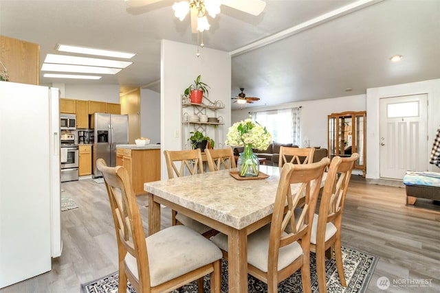 dining space featuring light wood finished floors and a ceiling fan