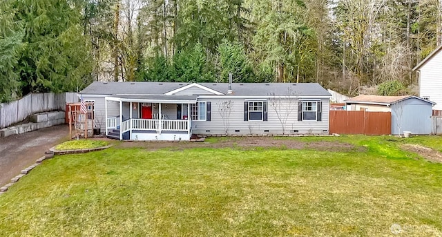 rear view of property with crawl space, a lawn, a porch, and fence