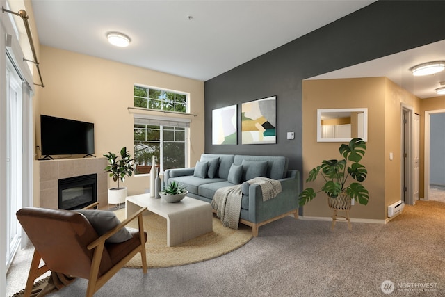 carpeted living area featuring baseboards and a tiled fireplace