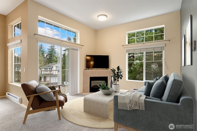 carpeted living area featuring a fireplace, baseboards, and baseboard heating