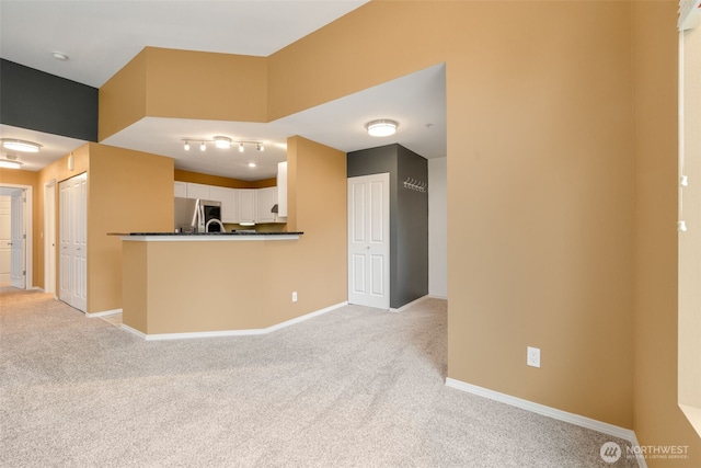 interior space featuring dark countertops, baseboards, white cabinets, and stainless steel fridge with ice dispenser