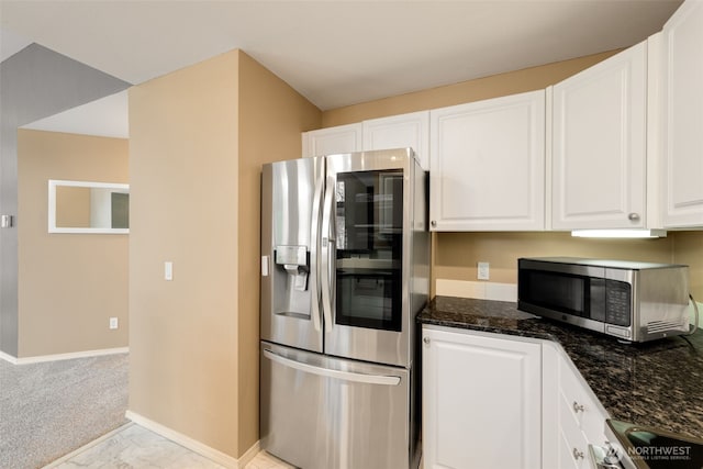 kitchen with baseboards, white cabinets, marble finish floor, appliances with stainless steel finishes, and dark stone counters