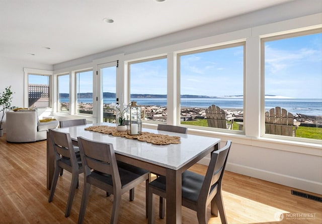 dining space with visible vents, a healthy amount of sunlight, and light wood-type flooring