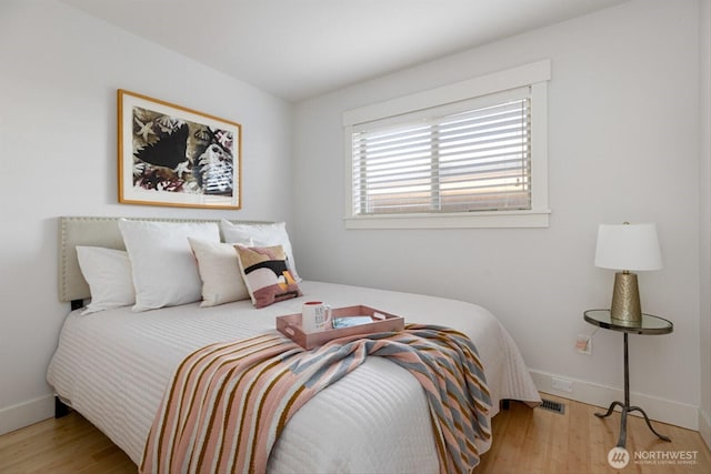 bedroom featuring visible vents, wood finished floors, and baseboards