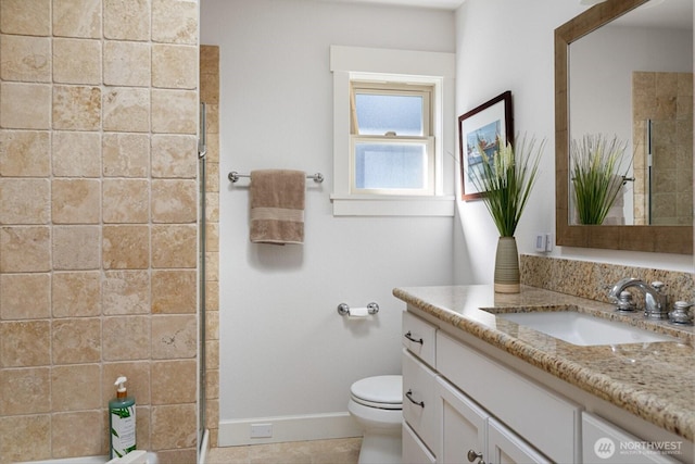 full bathroom featuring vanity, toilet, baseboards, and tiled shower