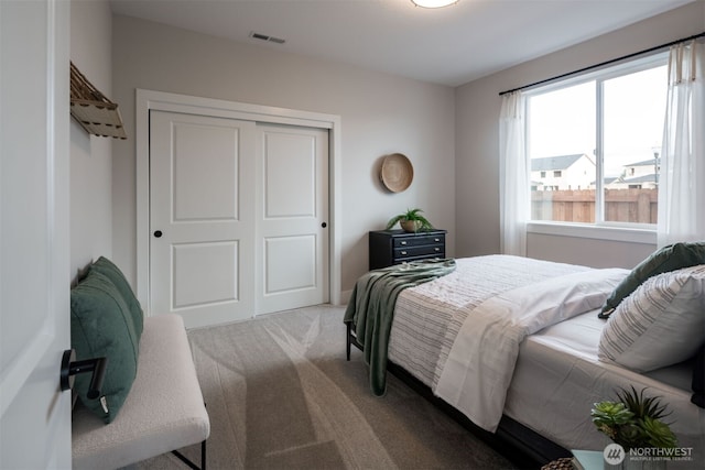 bedroom featuring a closet, visible vents, and carpet flooring