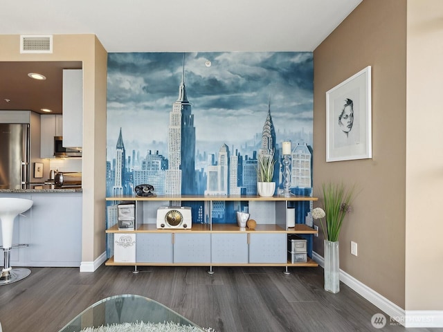 interior space featuring visible vents, stainless steel appliances, baseboards, and wood finished floors