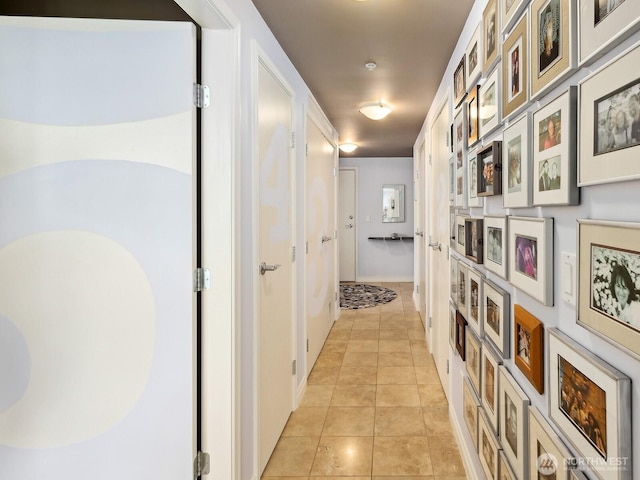 hallway featuring light tile patterned flooring and baseboards