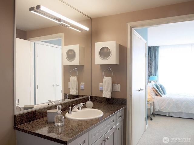 ensuite bathroom featuring connected bathroom, a healthy amount of sunlight, and vanity