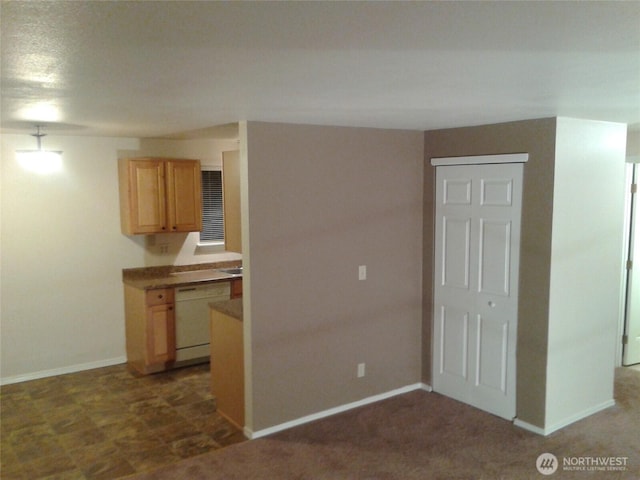 kitchen featuring dark colored carpet, light brown cabinets, dishwasher, and baseboards