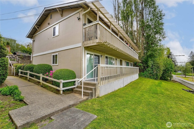 view of home's exterior with a lawn and stairway