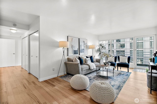 living area featuring light wood finished floors and baseboards