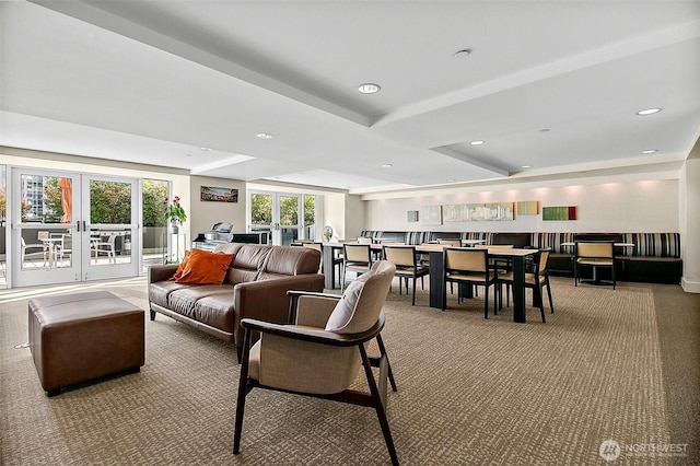 carpeted living room featuring recessed lighting, a raised ceiling, and french doors