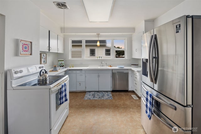 kitchen with stainless steel appliances, light countertops, visible vents, light tile patterned flooring, and a sink