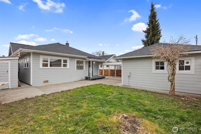 back of house with a lawn, a patio, a chimney, roof with shingles, and fence