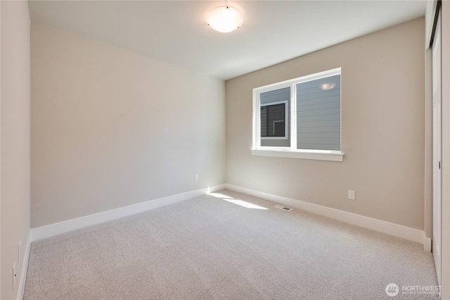 carpeted empty room featuring baseboards and visible vents