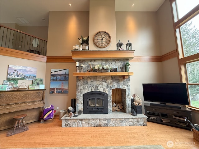 living room featuring a fireplace, a high ceiling, and wood finished floors