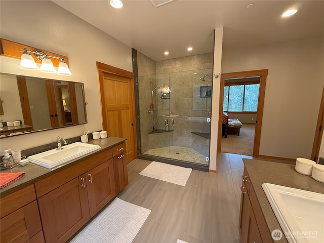 full bathroom featuring recessed lighting, two vanities, a sink, and a shower stall