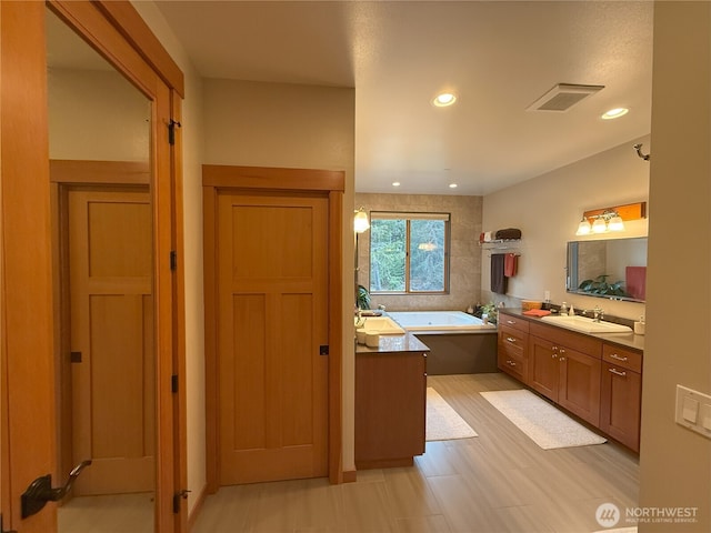 full bathroom with a bath, vanity, visible vents, and recessed lighting