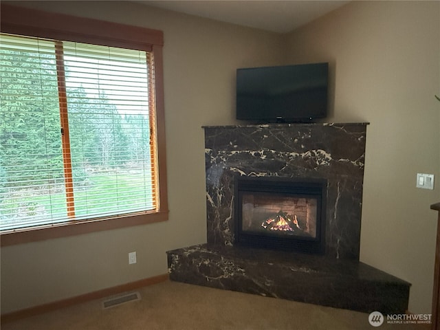 room details with carpet floors, baseboards, a fireplace, and visible vents