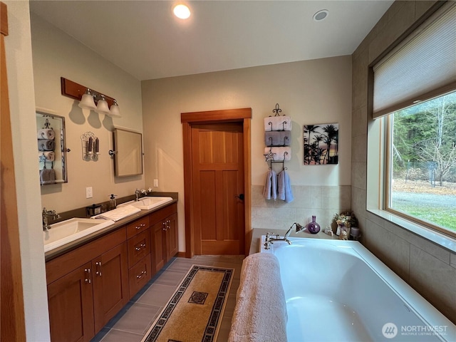 full bath with recessed lighting, double vanity, a sink, and a bath