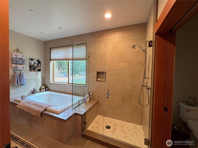 bathroom featuring toilet, a garden tub, a shower stall, and recessed lighting